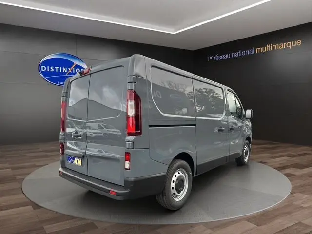 Vue 3/4 arrière droite du Renault Trafic Fourgon gris urbain 2025, avec portes arrière fermées et jantes acier.