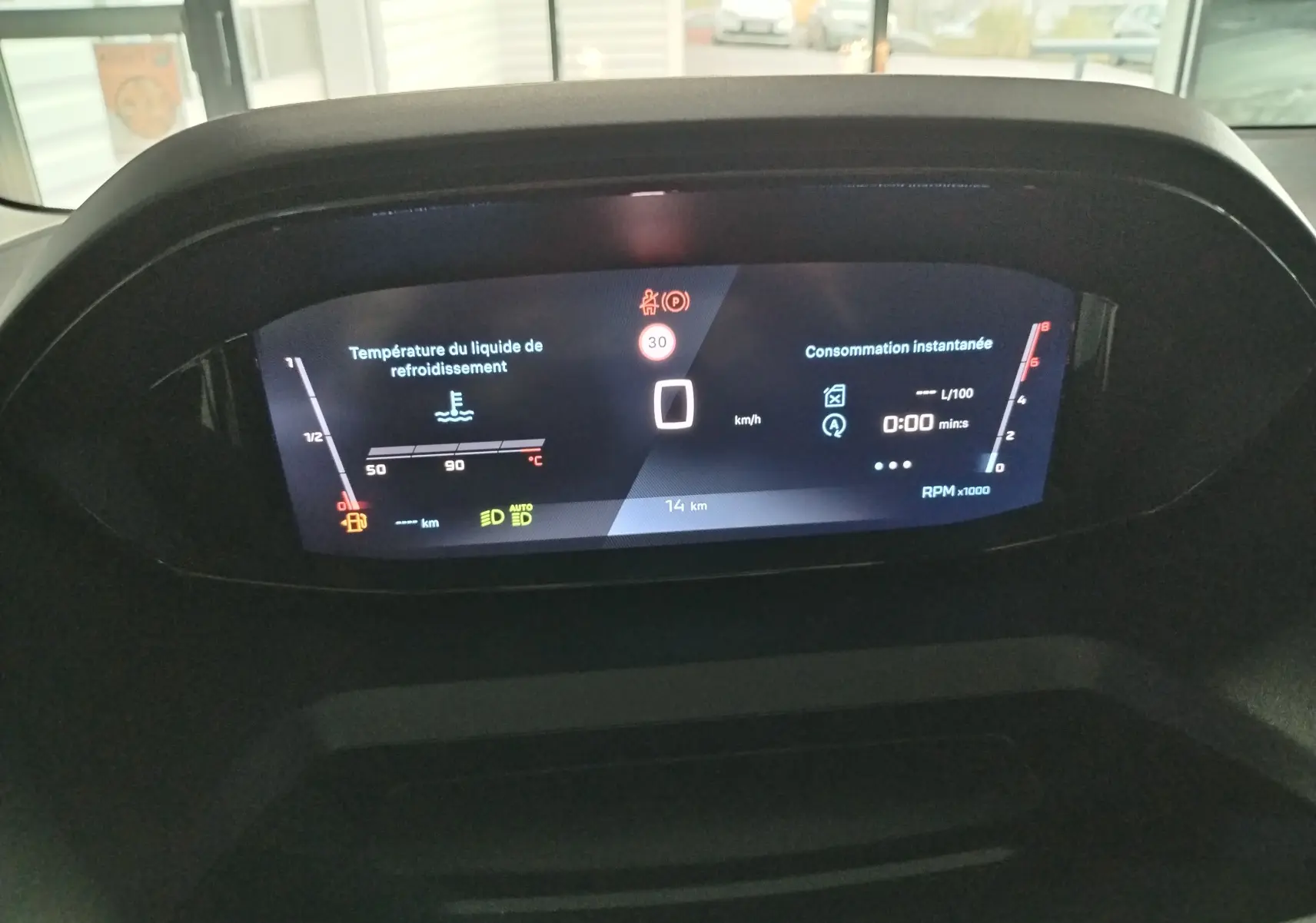 Vue rapprochée du tableau de bord numérique du Peugeot Partner FGN 2025 affichant la température liquide refroidissement et consommation.