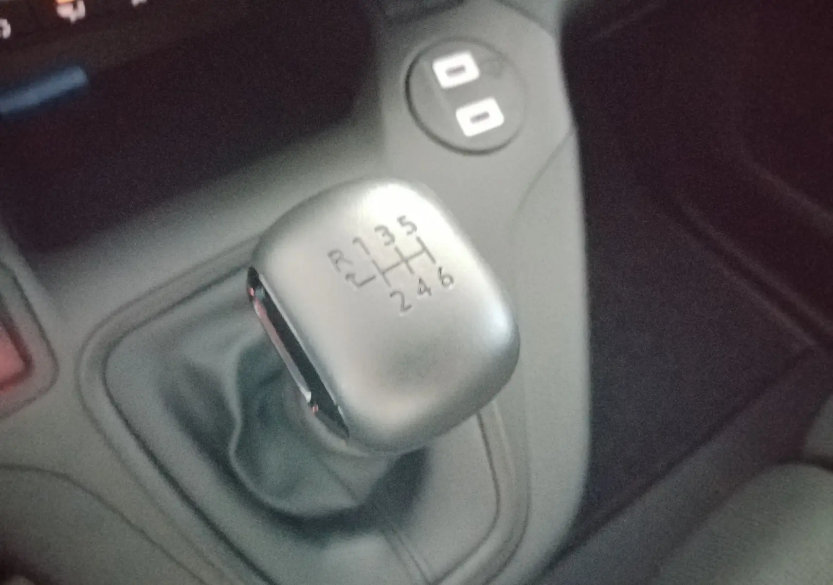 Gros plan sur le levier de vitesses manuel gris du Peugeot Partner FGN 2025, entouré de la console centrale noire.