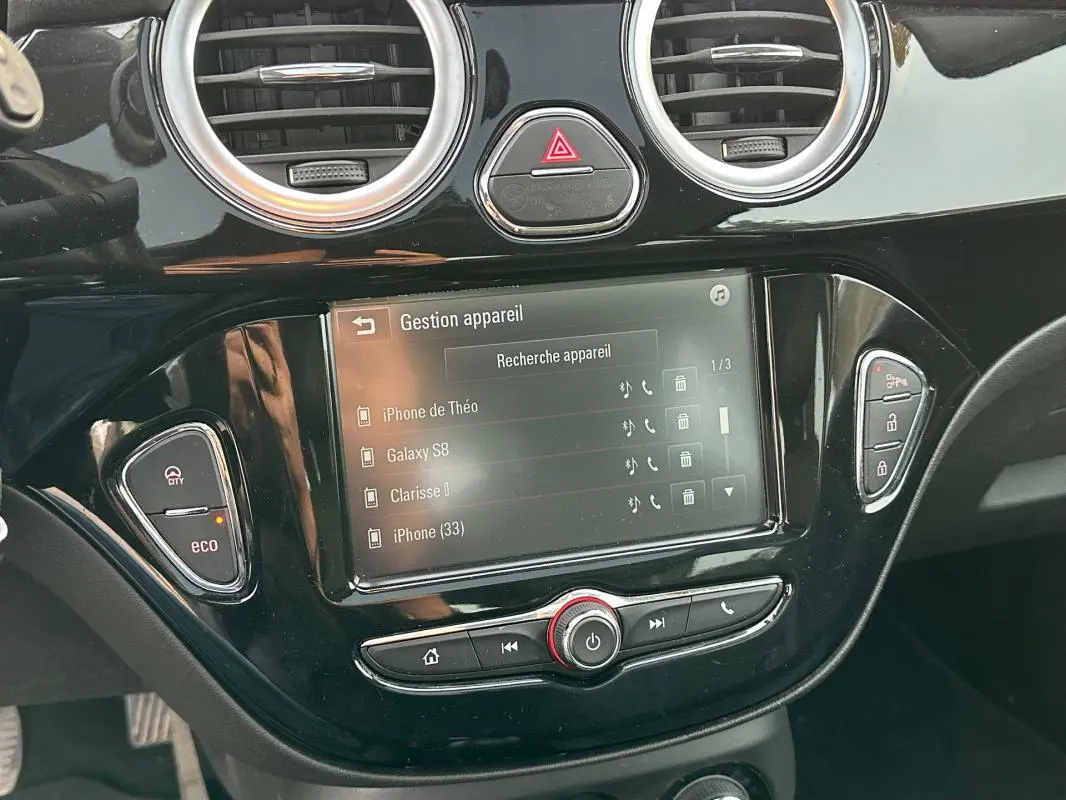 Écran tactile central de l’Opel Adam 2016 avec commandes de gestion Bluetooth et boutons de fonction noirs brillants.