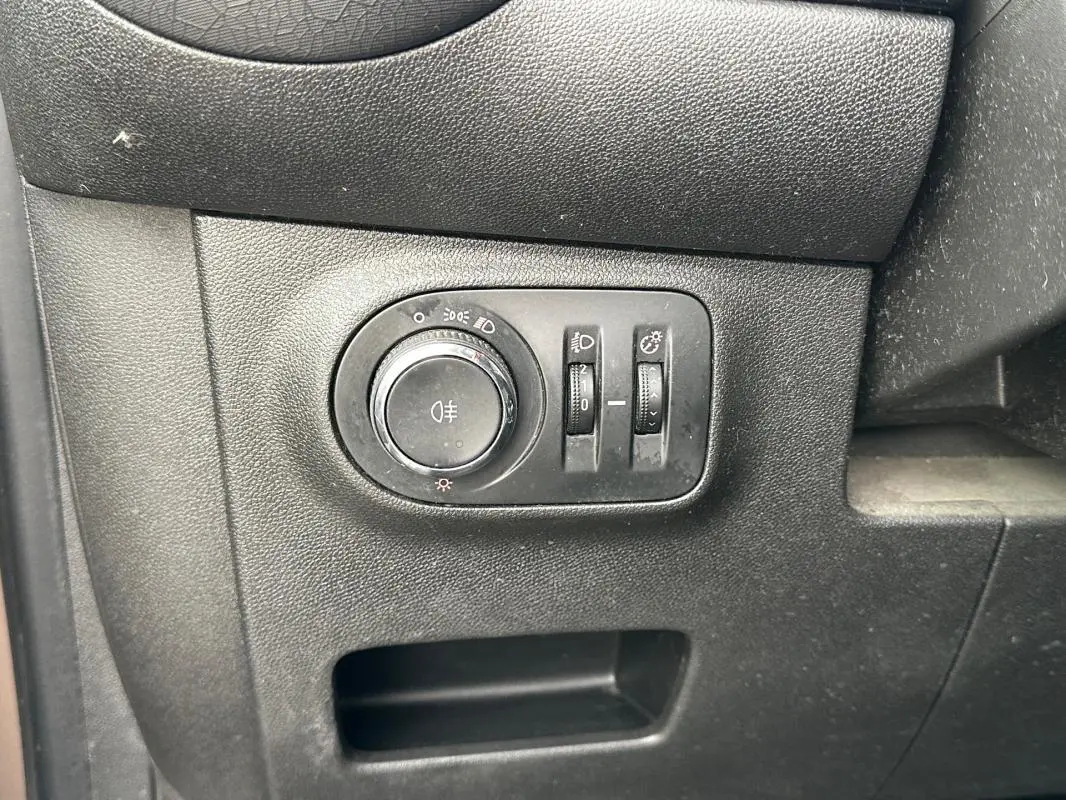 Gros plan sur le panneau de commande des phares et réglages d'éclairage intérieur de l'Opel Adam marron 2016.