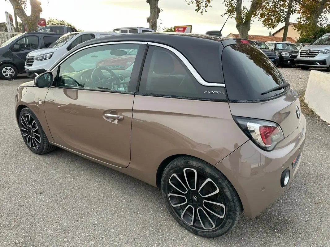 Opel Adam marron vue 3/4 arrière droit avec toit noir, jantes alliage 16 pouces et vitres surteintées.