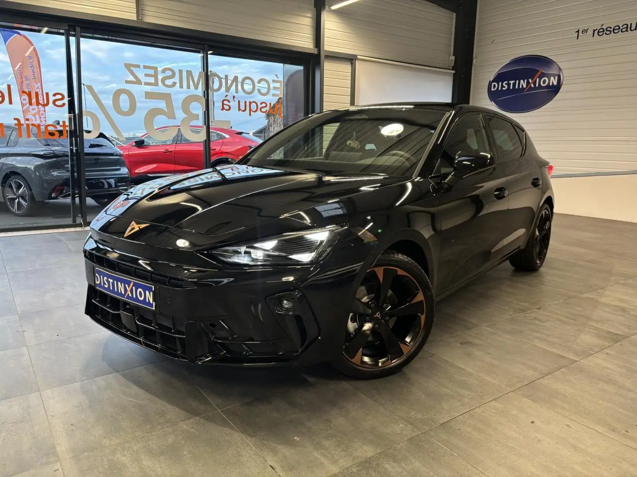 Vue 3/4 avant d'une CUPRA Leon noire midnight avec jantes alliage 18'' cuivrées et logo CUPRA sur calandre.