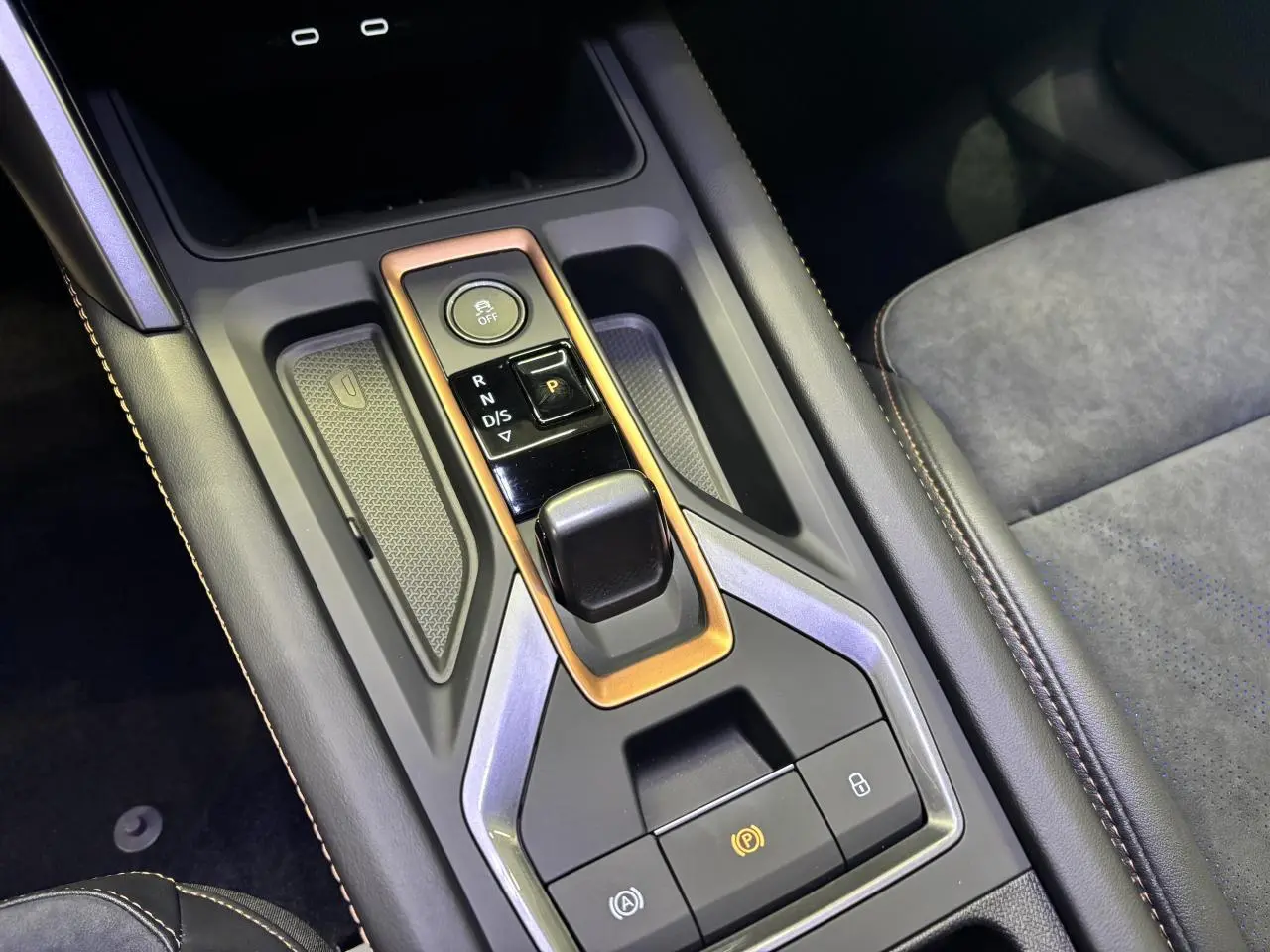 Vue rapprochée de la console centrale noire avec surpiqûres cuivrées et levier de vitesses automatique sur CUPRA Leon noir midnight.