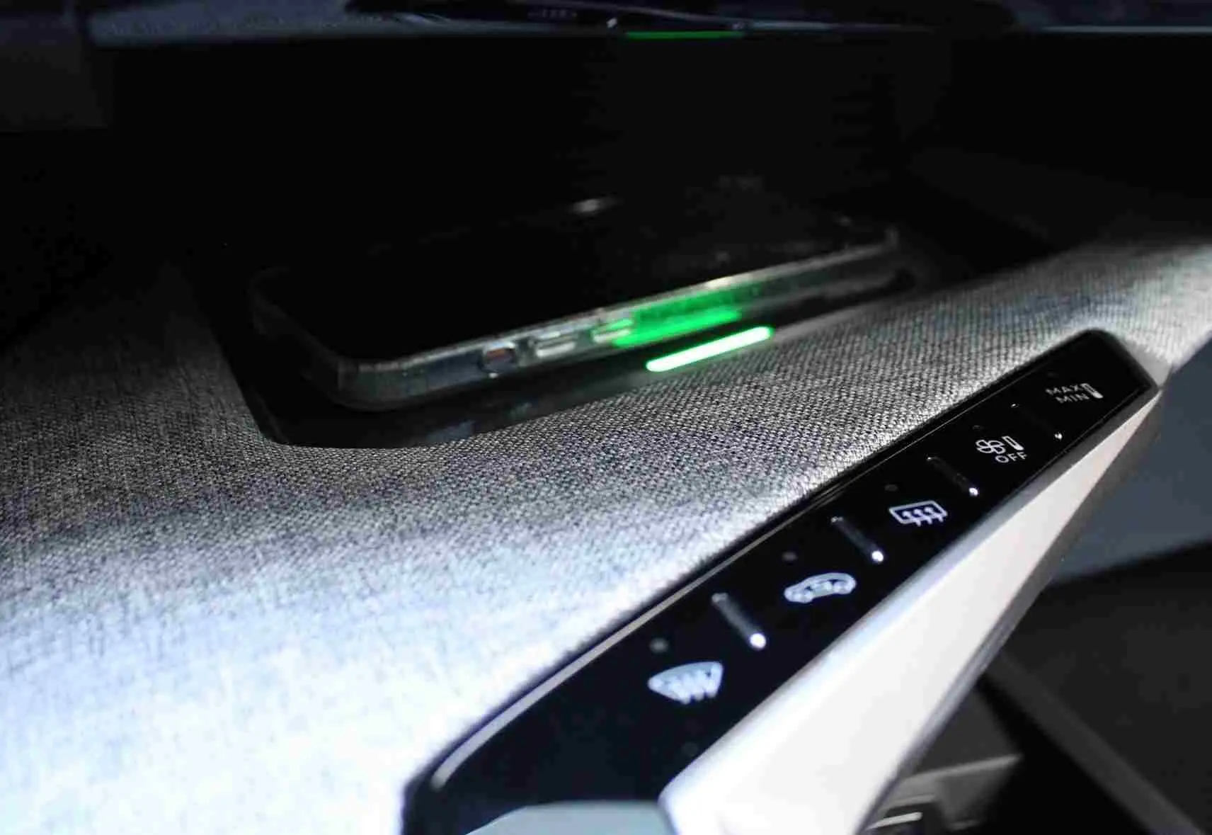 Vue intérieure rapprochée de la console centrale et du tableau de bord numérique du Peugeot 5008 Hybrid 2025, finition tissu gris noir.
