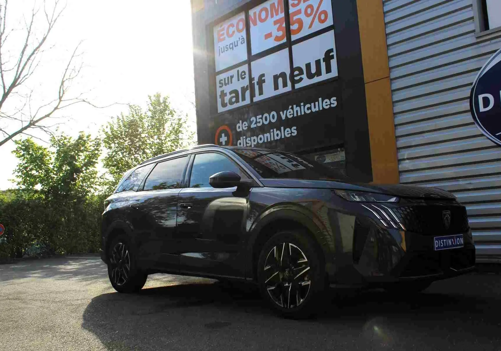 Gros plan sur l'arrière gris titane métallisé d'un Peugeot 5008 Hybrid avec le badge "HYBRID" visible.