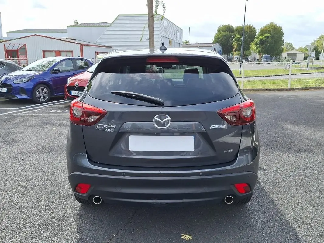 Vue arrière d'un Mazda CX-5 gris 2015 avec double sortie d'échappement et feux rouges distinctifs.