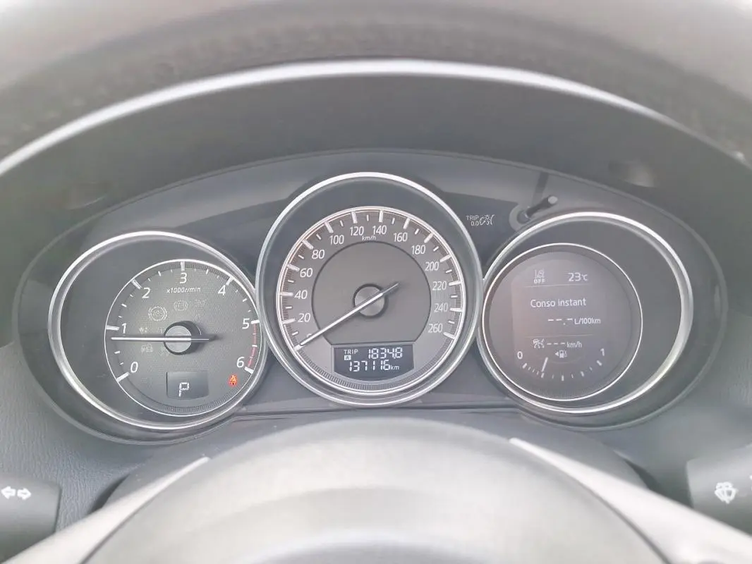 Tableau de bord du Mazda CX-5 gris 2015, vue frontale sur compte-tours, vitesse et écran multifonction.