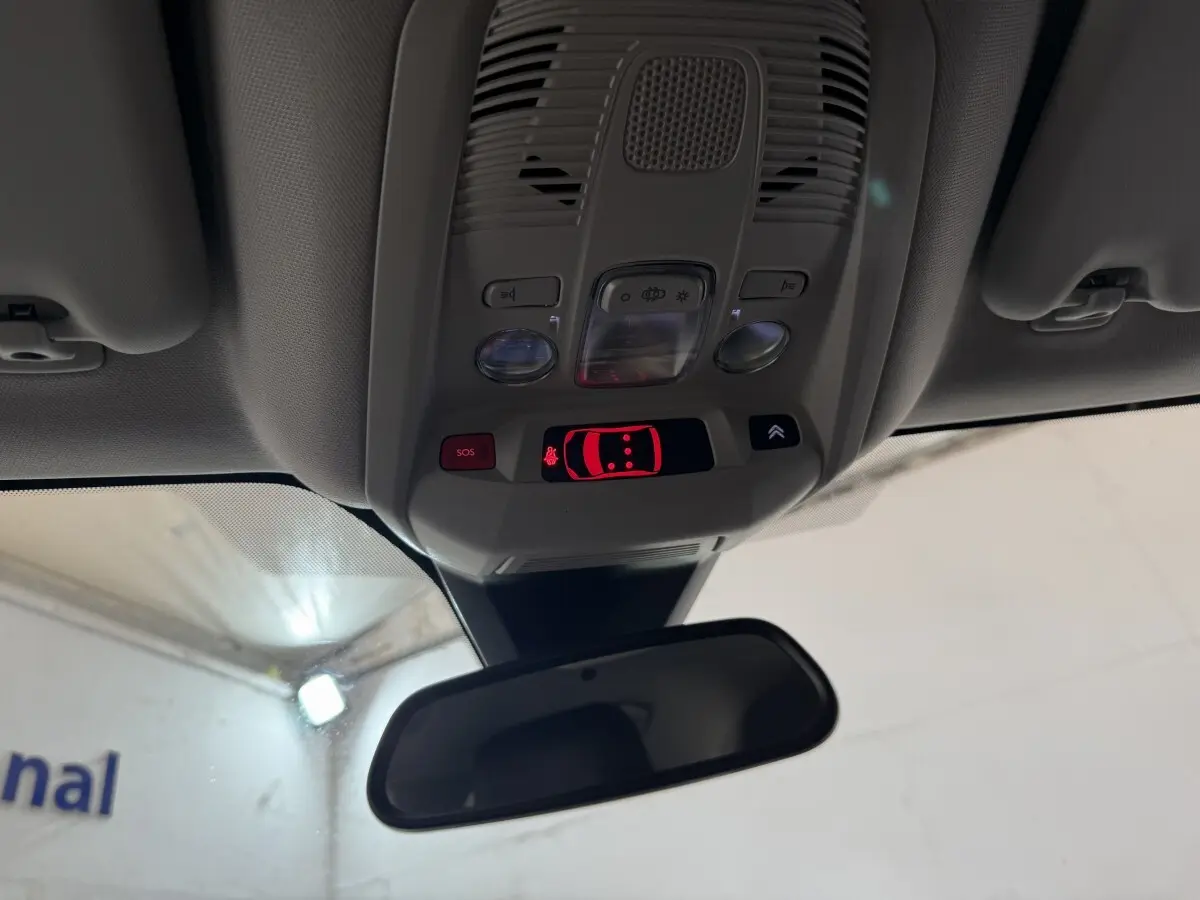 Vue intérieure du plafonnier et rétroviseur d'une Citroën C5 Aircross 2023, avec commandes et affichage lumineux rouge.