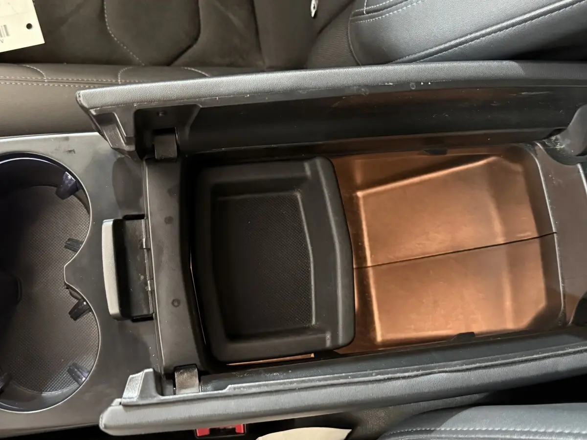 Vue intérieure en plongée du rangement central ouvert du Citroën C5 Aircross gris clair, montrant le compartiment de console entre les sièges.