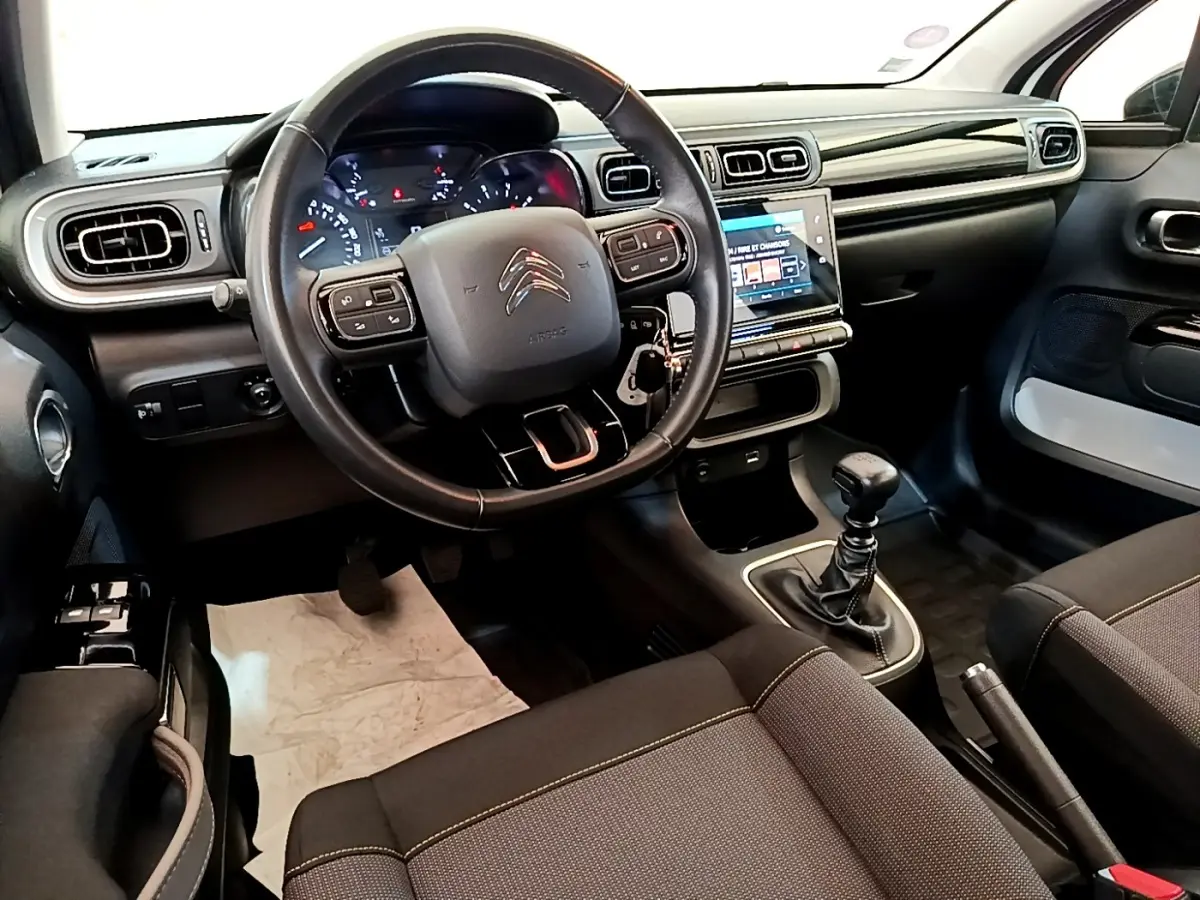 Vue intérieure avant de la Citroën C3 2021, volant cuir, tableau de bord avec écran tactile et boîte manuelle.