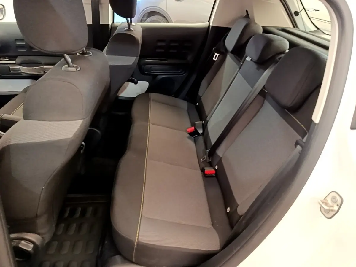 Vue intérieure côté droit montrant la banquette arrière grise et noire d'une Citroën C3 blanche 2021.