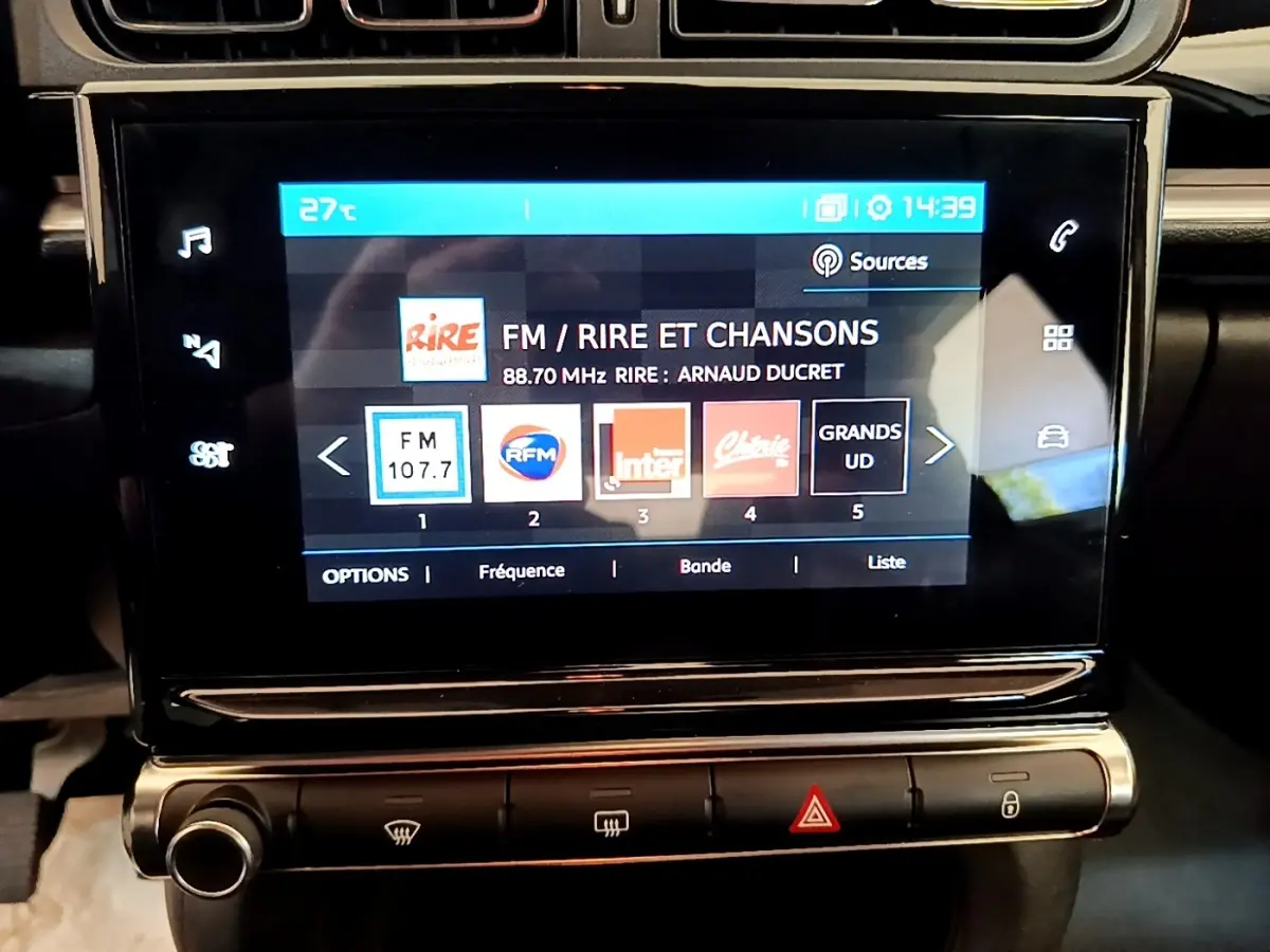 Écran tactile central de la Citroën C3 blanche 2021 affichant la radio FM et les options multimédia.
