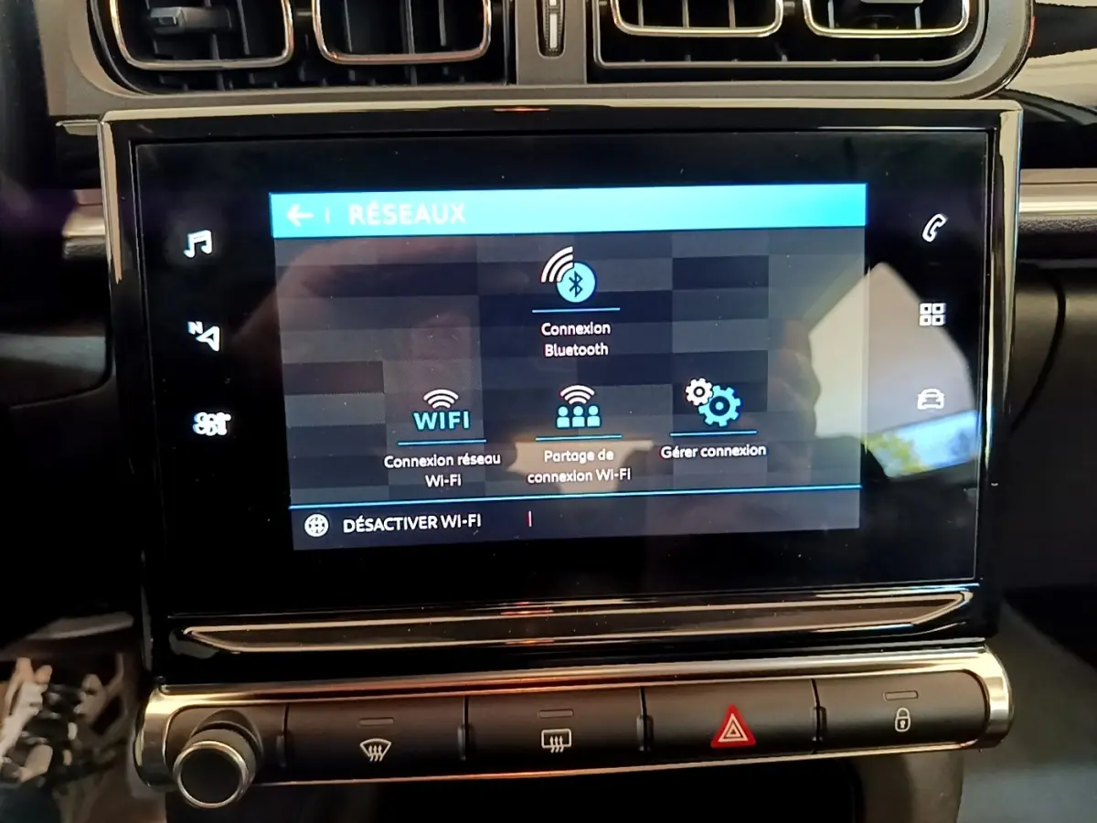 Écran tactile central affichant les options réseau Wi-Fi et Bluetooth dans l’habitacle d’une Citroën C3 blanche.