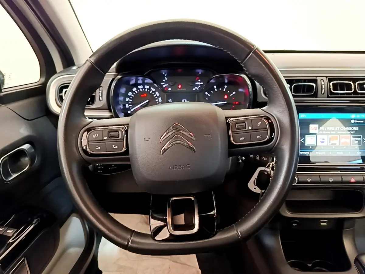 Vue rapprochée du volant cuir noir de la Citroën C3 2021 avec tableau de bord et écran tactile visible à droite.
