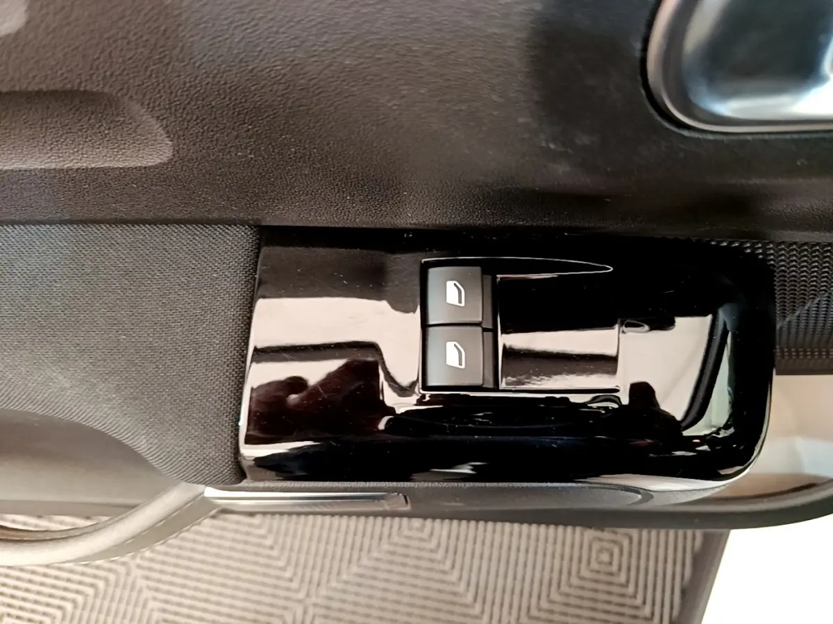 Gros plan sur les commandes de lève-vitres électriques côté conducteur d'une Citroën C3 blanche de 2021.