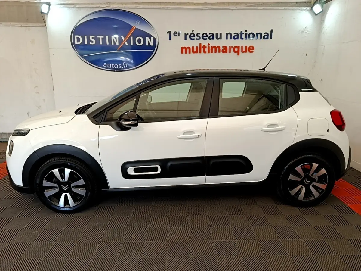Profil droit d'une Citroën C3 blanche 2021 avec toit noir et protections latérales noires distinctives.