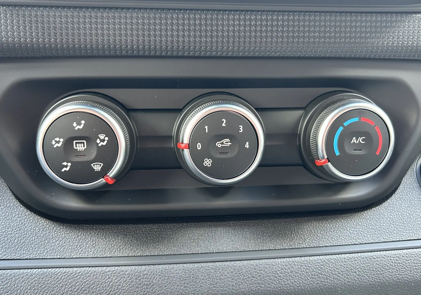 Gros plan sur les commandes de climatisation du Renault Trafic Fourgon L1H1 gris Highland, avec réglages ventilation et A/C visibles.