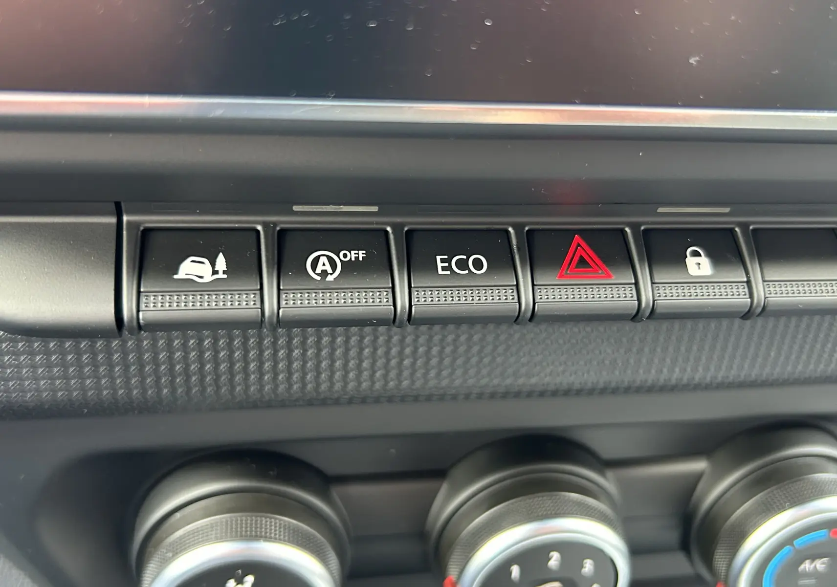 Gros plan sur les boutons de commande du tableau de bord du Renault Trafic Fourgon L1H1, avec fonctions ECO et verrouillage.