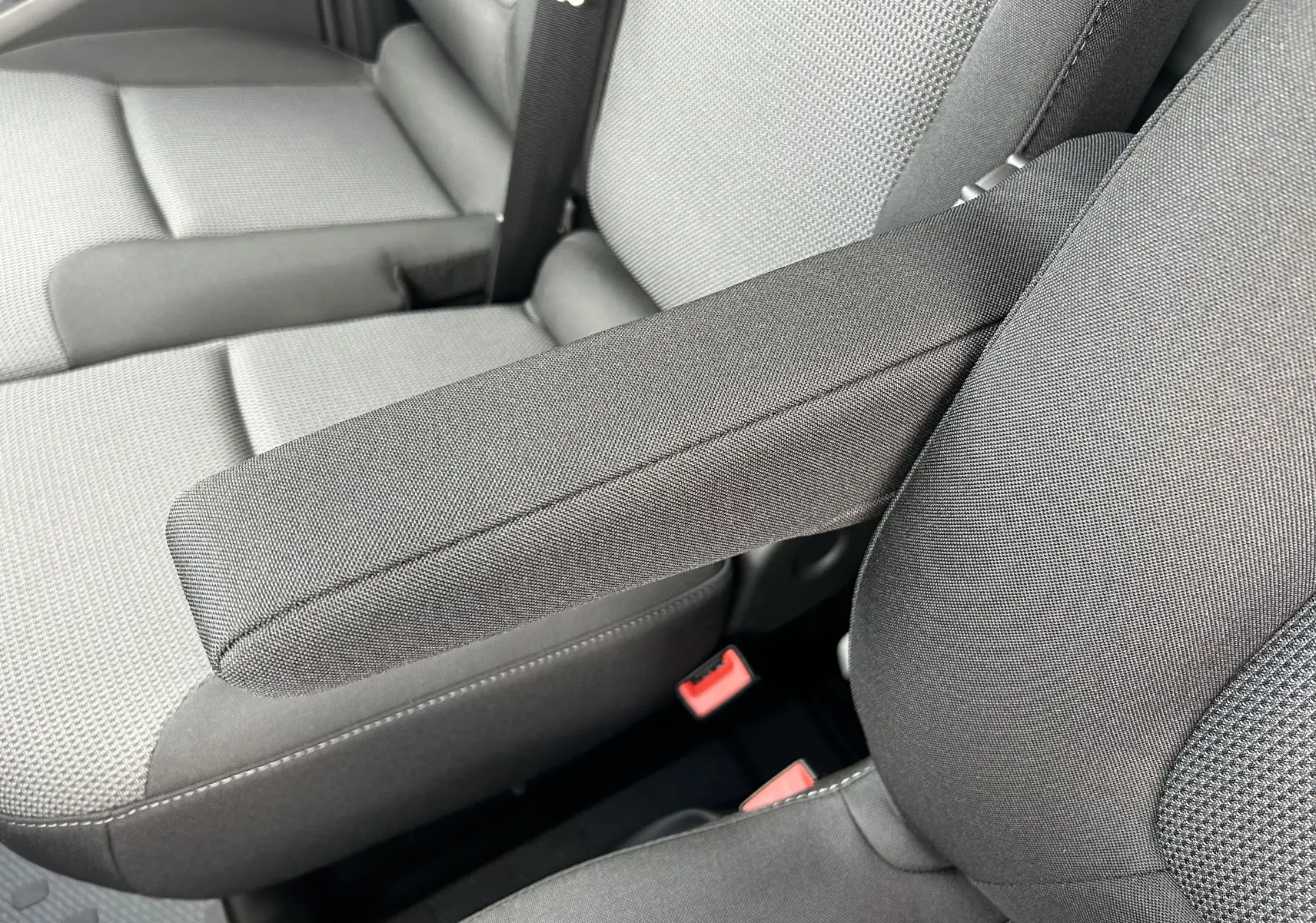 Détail de l'accoudoir central en tissu gris sur les sièges avant du Renault Trafic Fourgon L1H1 2025.