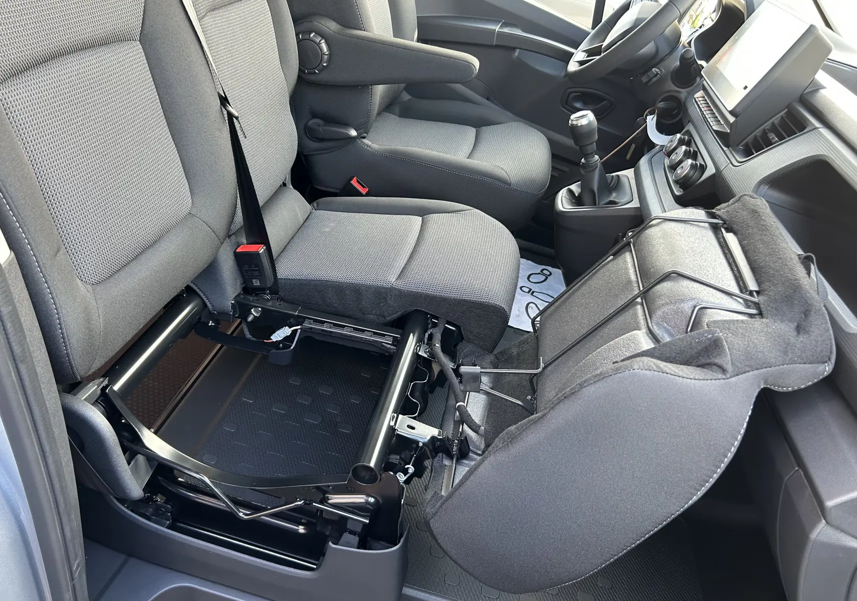 Vue intérieure côté droit du Renault Trafic Fourgon gris Highland 2025, siège passager avant relevé dévoilant la structure métallique.