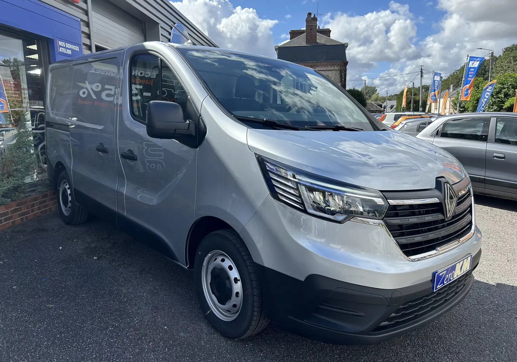 Renault Trafic Fourgon gris Highland en 3/4 avant droit, avec calandre noire et jantes acier simples.