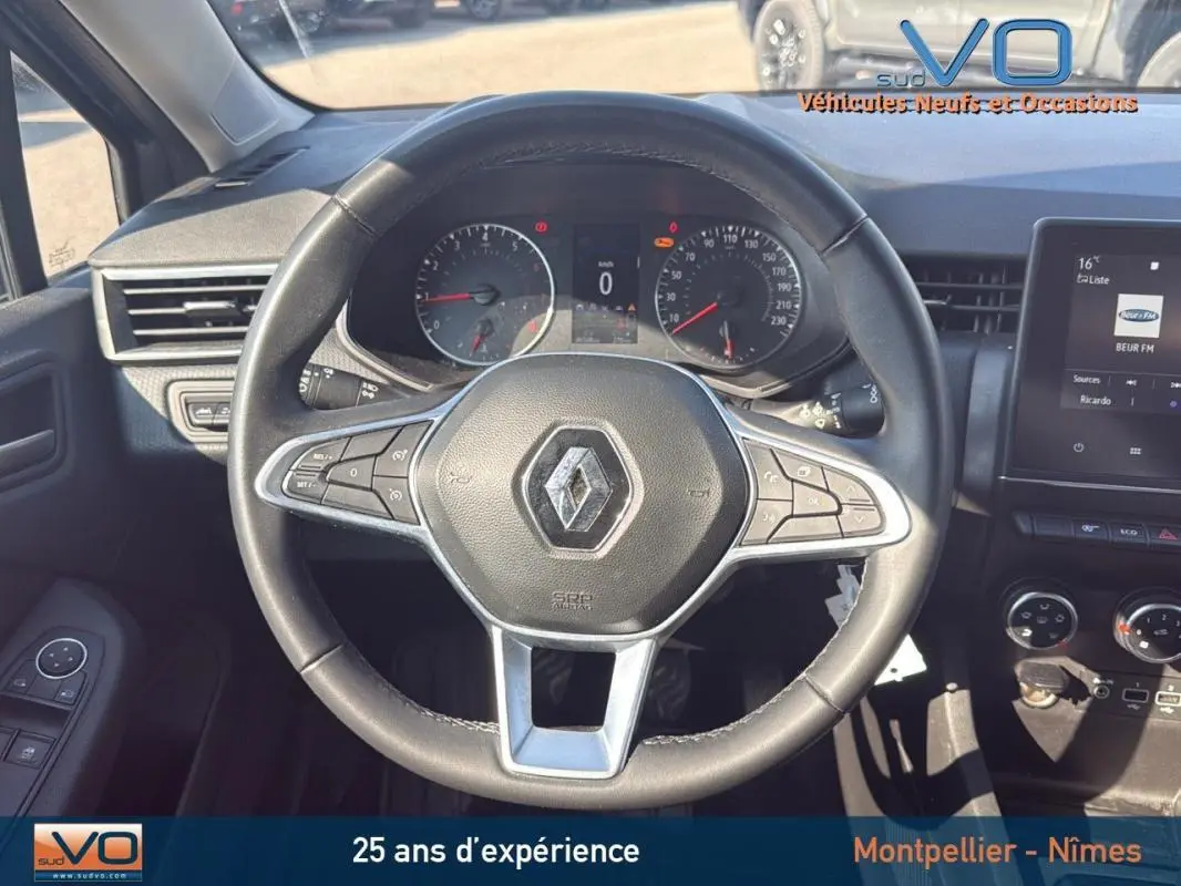 Vue rapprochée du volant noir de la Renault Clio V TCe 90 Equilibre 2022 avec tableau de bord et écran tactile visibles.