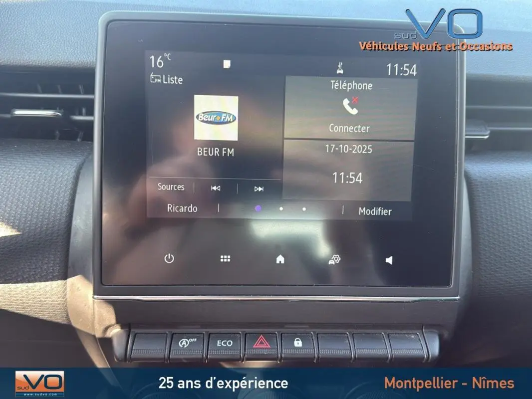 Écran tactile central de la Renault Clio gris 2022 affichant radio Beur FM et commandes de climatisation manuelle.