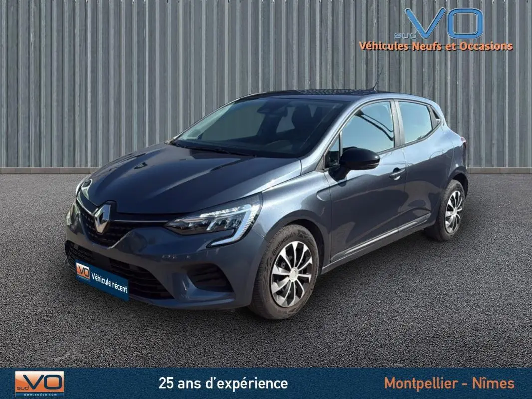 Renault Clio gris 2022 en 3/4 avant droit, avec jantes alliage et calandre distinctive sous un ciel dégagé.
