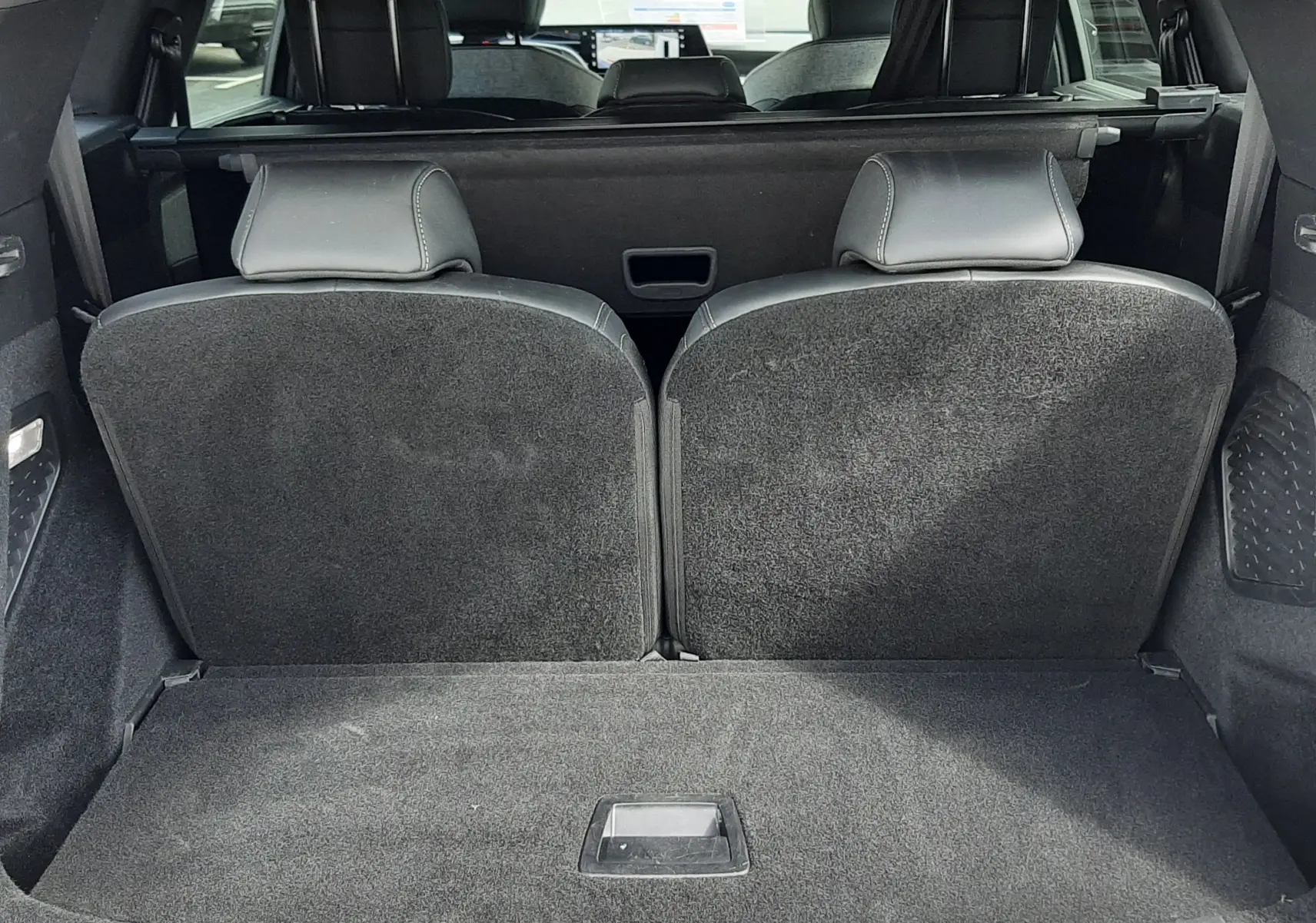 Vue arrière du coffre ouvert du Peugeot 5008 gris titane, montrant les sièges arrière et l'espace de chargement.