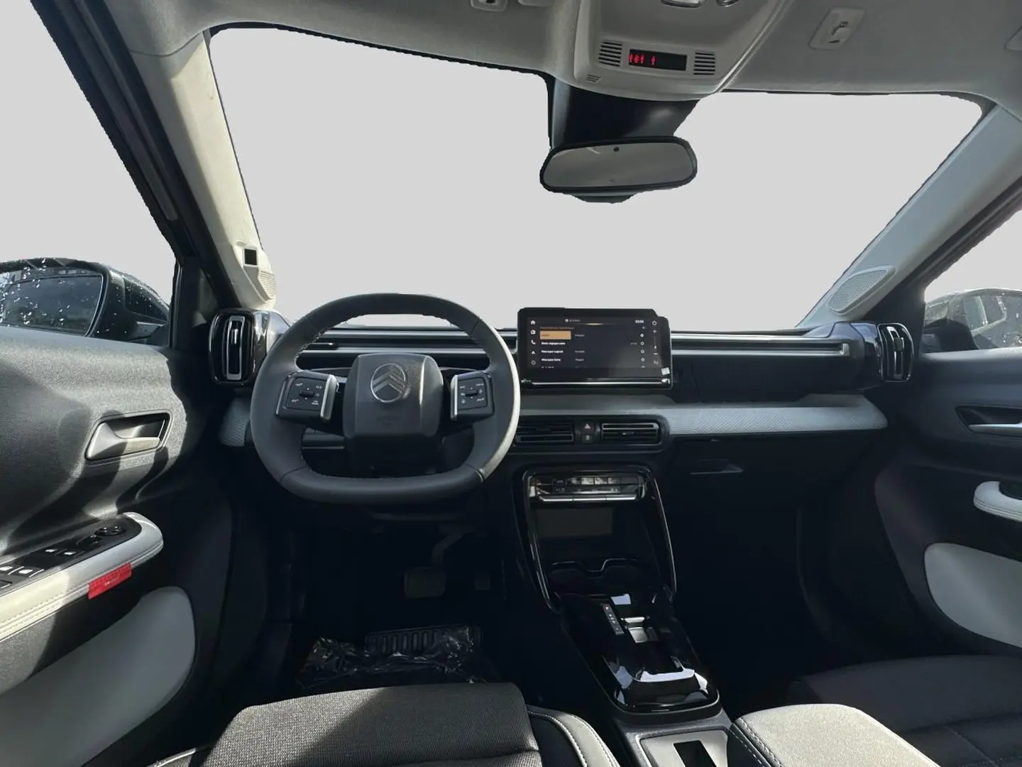 Vue intérieure avant du tableau de bord noir et gris du Citroën C3 Aircross 2026 avec écran tactile central et volant multifonction.