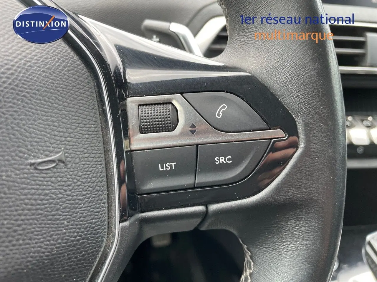Gros plan sur les commandes gauche du volant noir du Peugeot 3008 gris, avec boutons LIST, SRC et téléphone.
