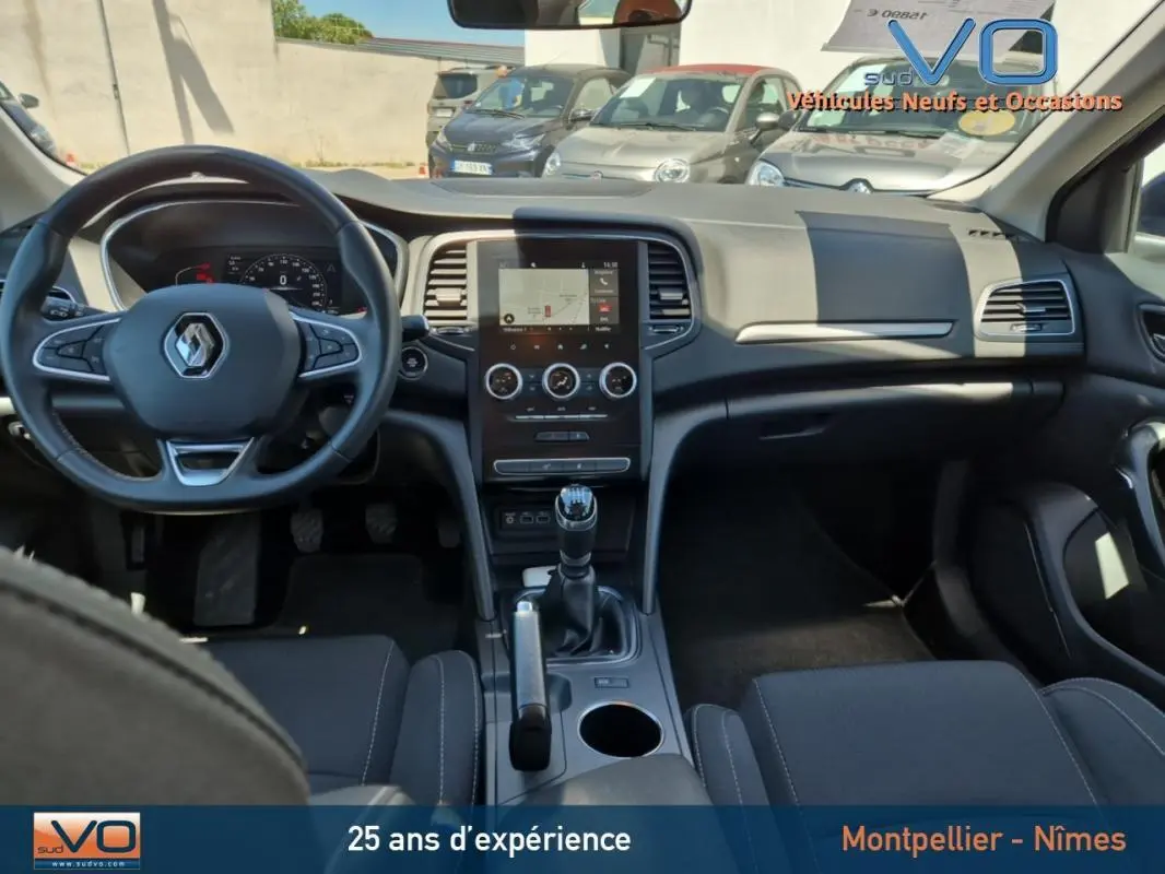 Intérieur de la Renault Mégane IV Business 2020, vue de face sur le tableau de bord gris avec écran tactile et boîte manuelle.