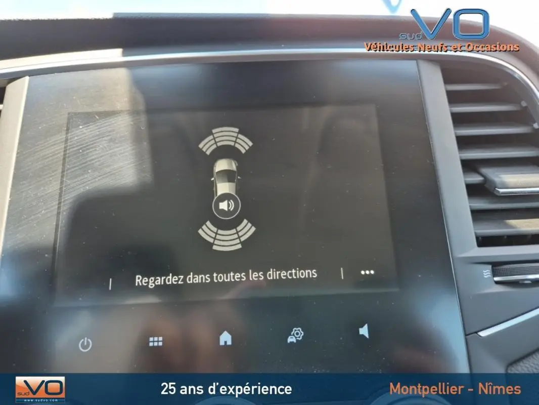 Écran tactile du système d'aide au stationnement de la Renault Mégane IV Business, intérieur moderne gris.