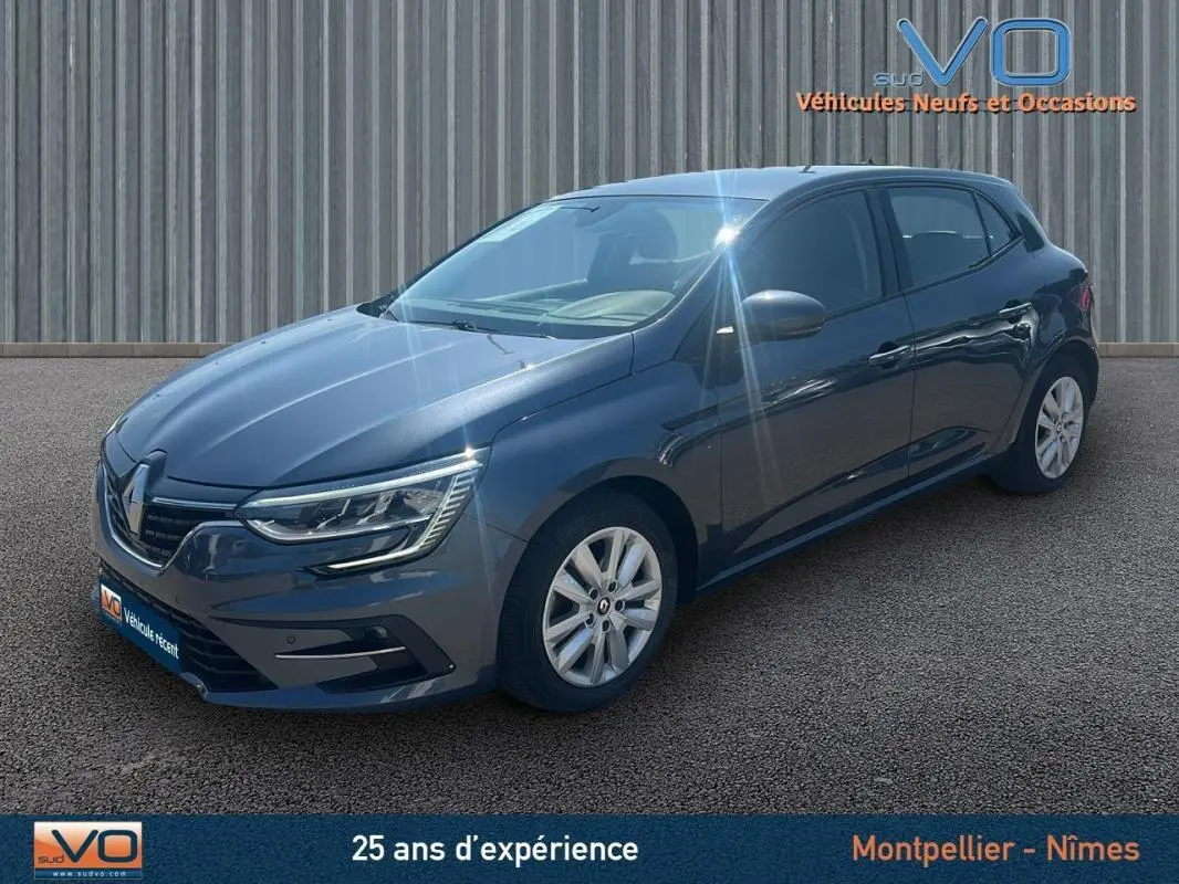 Renault Mégane IV Berline gris vue 3/4 avant droit avec jantes 16 pouces et phares LED allumés.