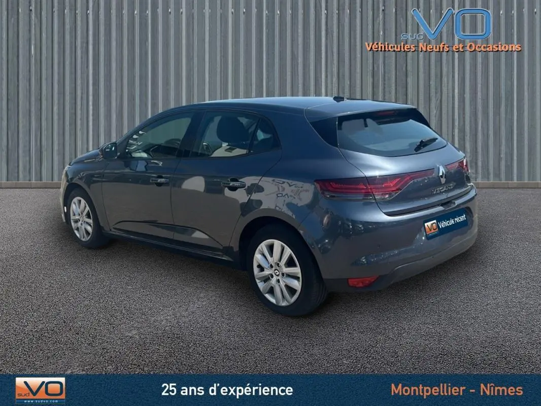 Renault Mégane IV gris vue 3/4 arrière droit, avec feux arrière allongés et jantes 16 pouces visibles.