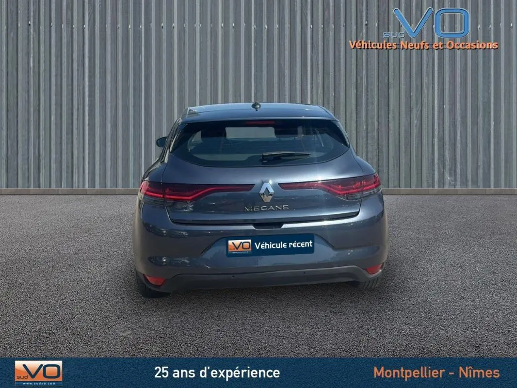Vue arrière d'une Renault Mégane IV grise, mettant en valeur ses feux LED étirés et son design compact.
