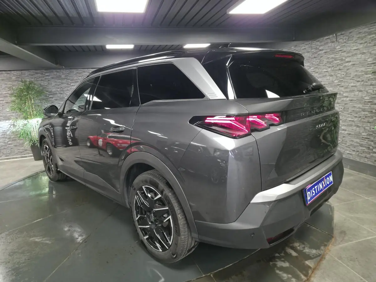 Vue 3/4 arrière droite du Peugeot 5008 gris métallisé avec feux arrière LED 3 griffes et jantes alliage noires.
