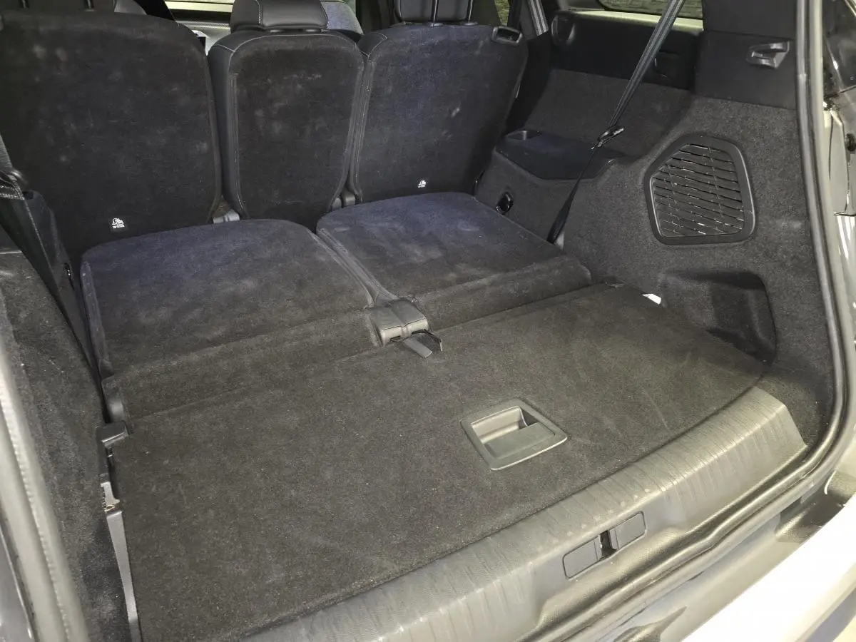 Coffre arrière du Peugeot 5008 gris 2025 avec banquette rabattue et espace de chargement plat.