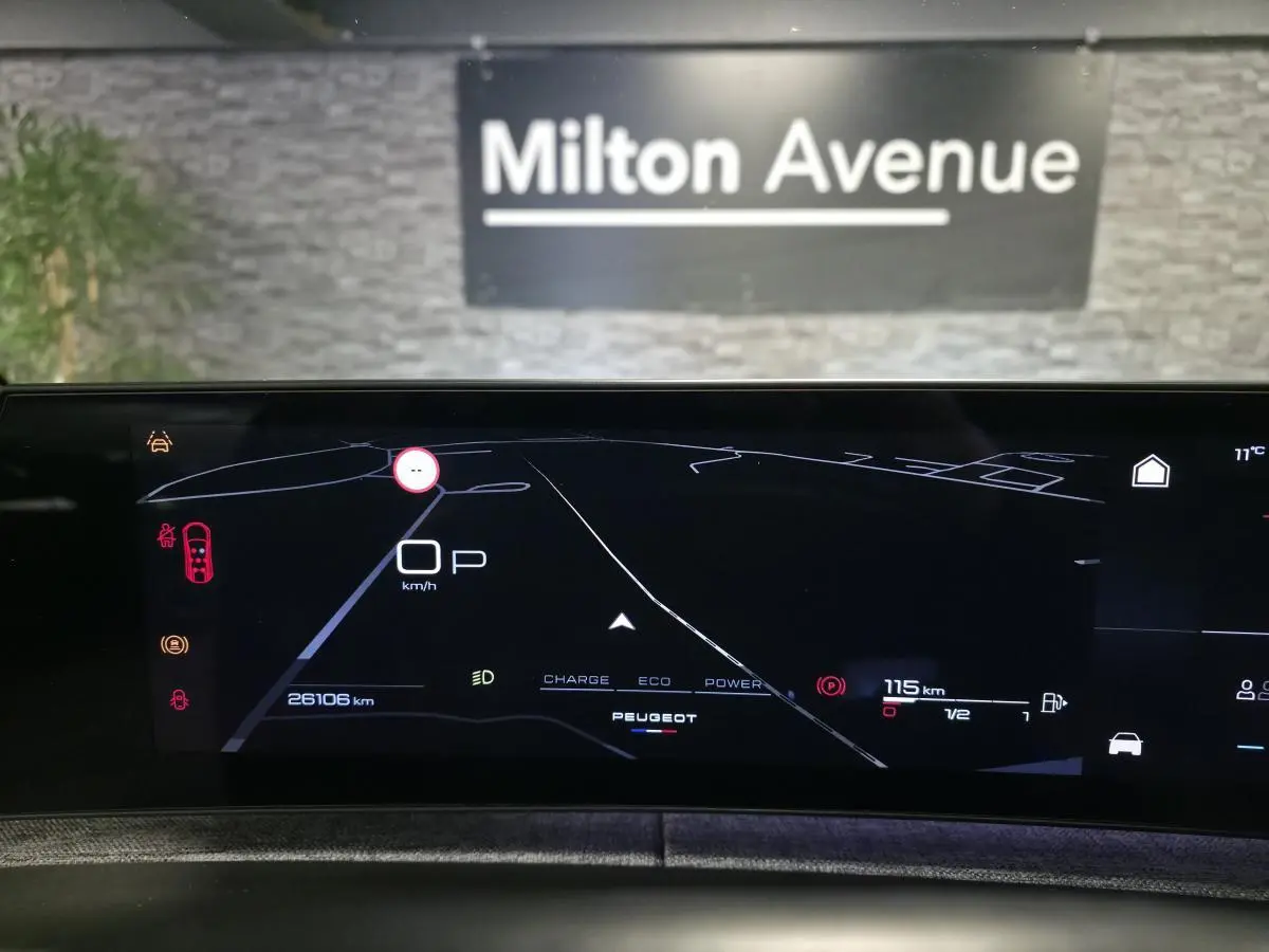 Affichage numérique du tableau de bord du Peugeot 5008 gris, vue frontale centrée sur l'écran de navigation et informations de conduite.