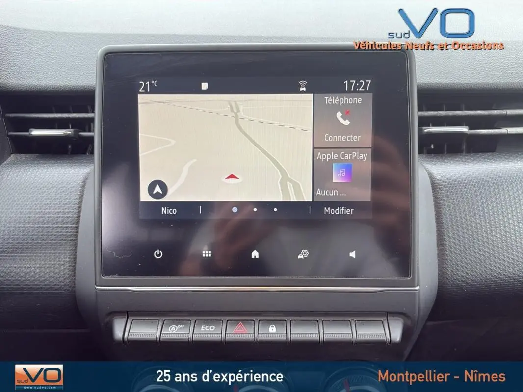 Écran tactile central avec navigation et commandes dans l’habitacle d’une Renault Clio gris foncé, vue de face.