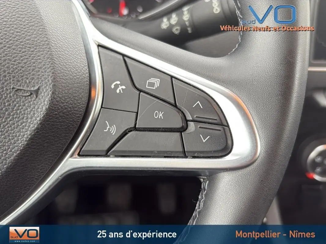 Gros plan sur les commandes multifonctions à droite du volant d'une Renault Clio gris foncé, version Business 2020.