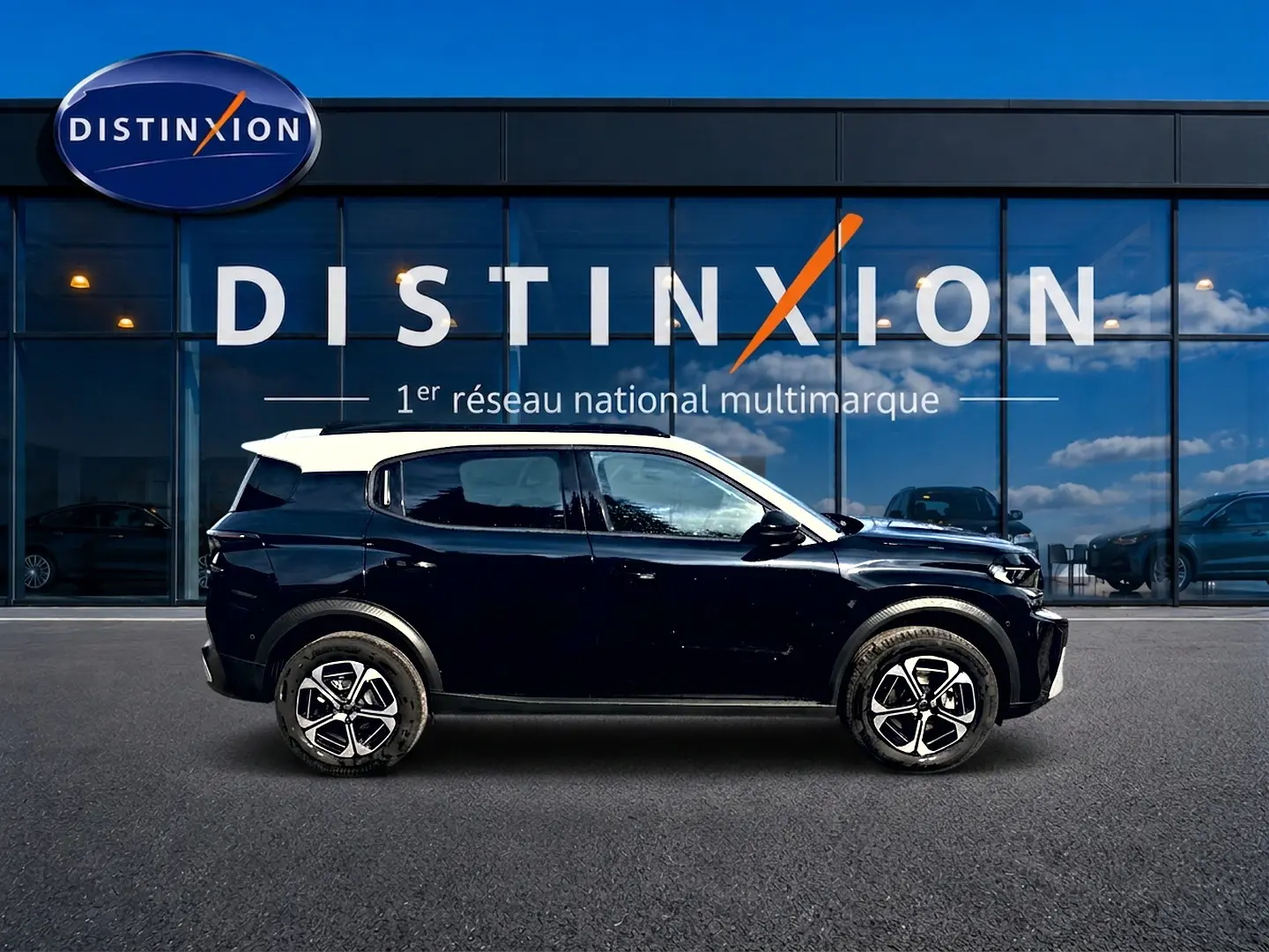 Profil côté gauche d'un Citroën C3 Aircross noir avec toit blanc, jantes alu et barres de toit visibles.