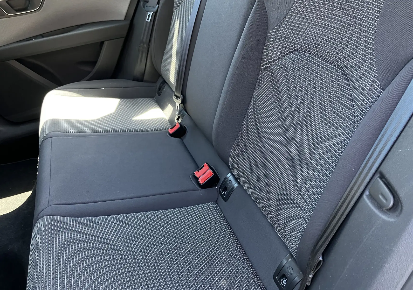 Vue rapprochée des sièges arrière noirs en tissu de la SEAT LEON 2018, côté droit avec ceinture de sécurité visible.