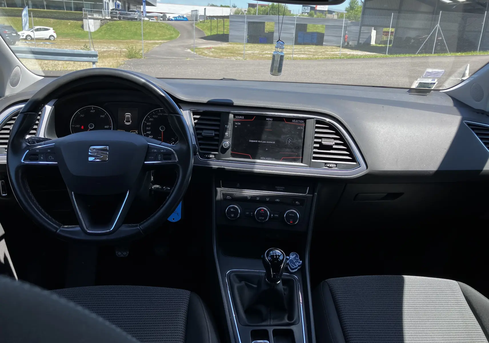 Vue intérieure avant du tableau de bord noir et volant multifonction d'une SEAT LEON 1,6L TDI 115 STYLE de 2018 avec boîte manuelle.