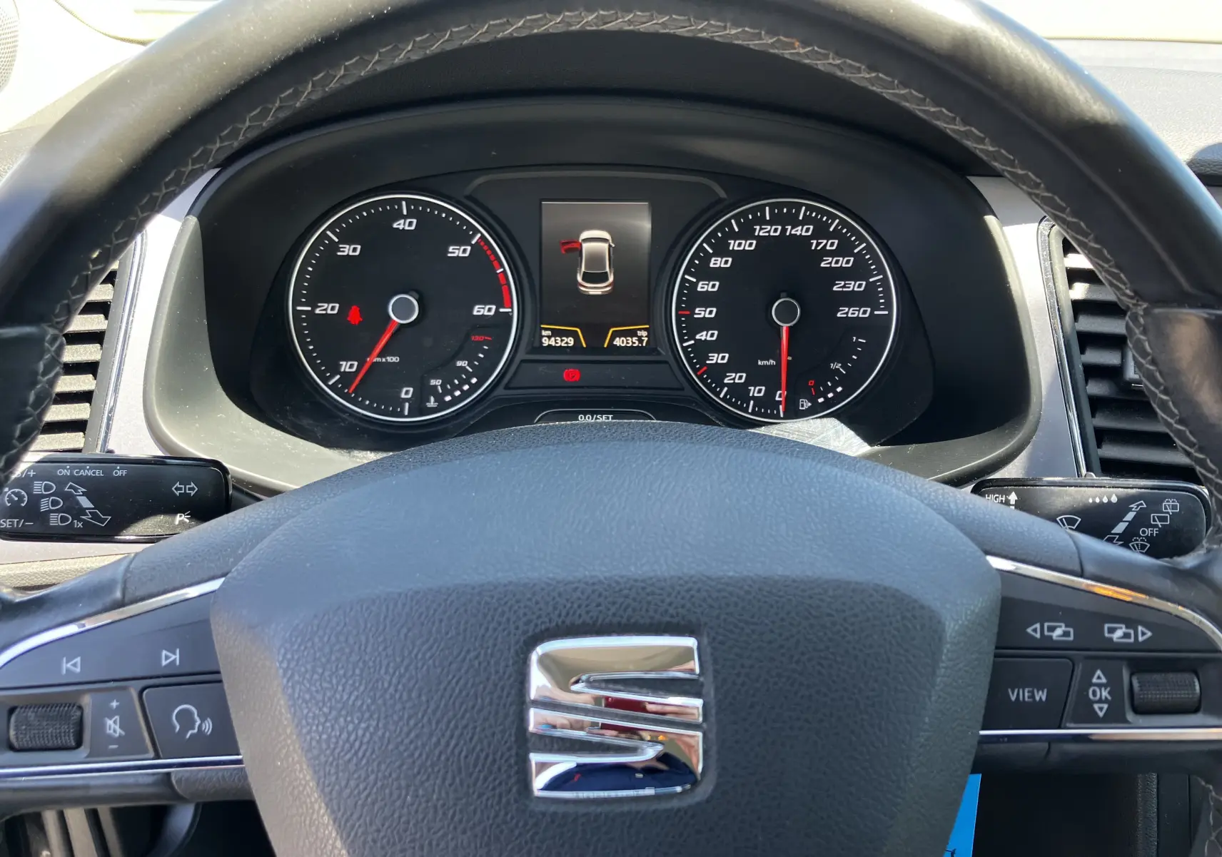 Vue rapprochée du tableau de bord et volant noir d'une SEAT LEON 1,6L TDI 115 STYLE de 2018 avec affichage digital central.