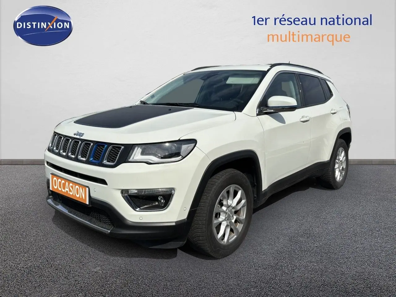 Jeep Compass blanc vue 3/4 avant droit avec capot noir et calandre distinctive bleue.