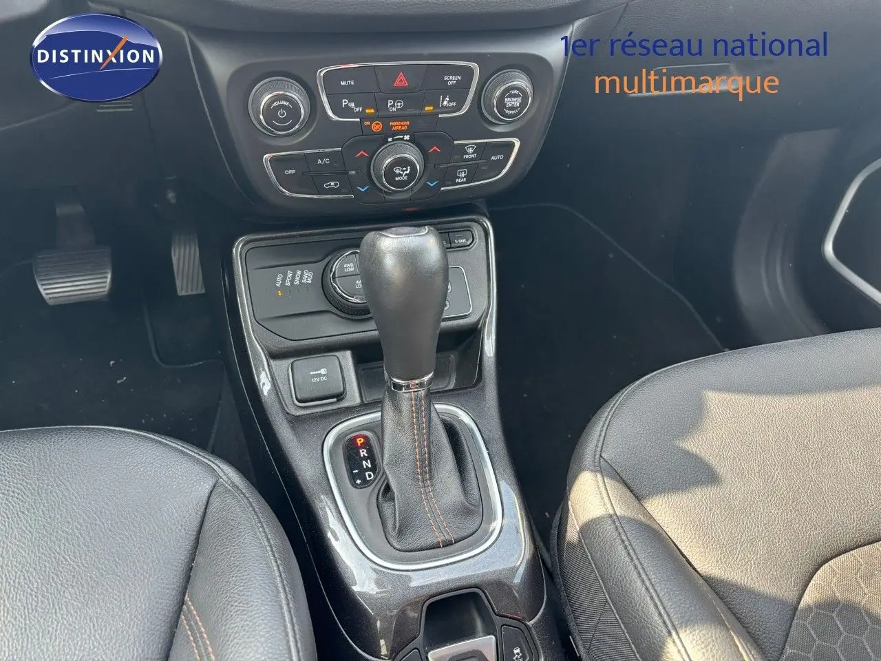 Le levier de vitesses automatique et la console centrale du Jeep Compass blanc, avec sièges en cuir noir visibles de près.