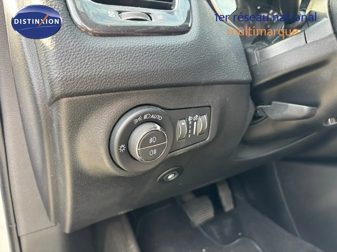 Gros plan sur le panneau de commande des phares côté gauche dans l'habitacle du Jeep Compass blanc hybride rechargeable.