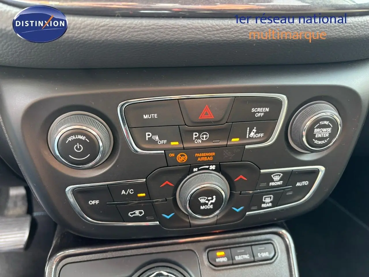 Gros plan sur la console centrale noire du Jeep Compass hybride rechargeable 2021, montrant les commandes de climatisation et audio.